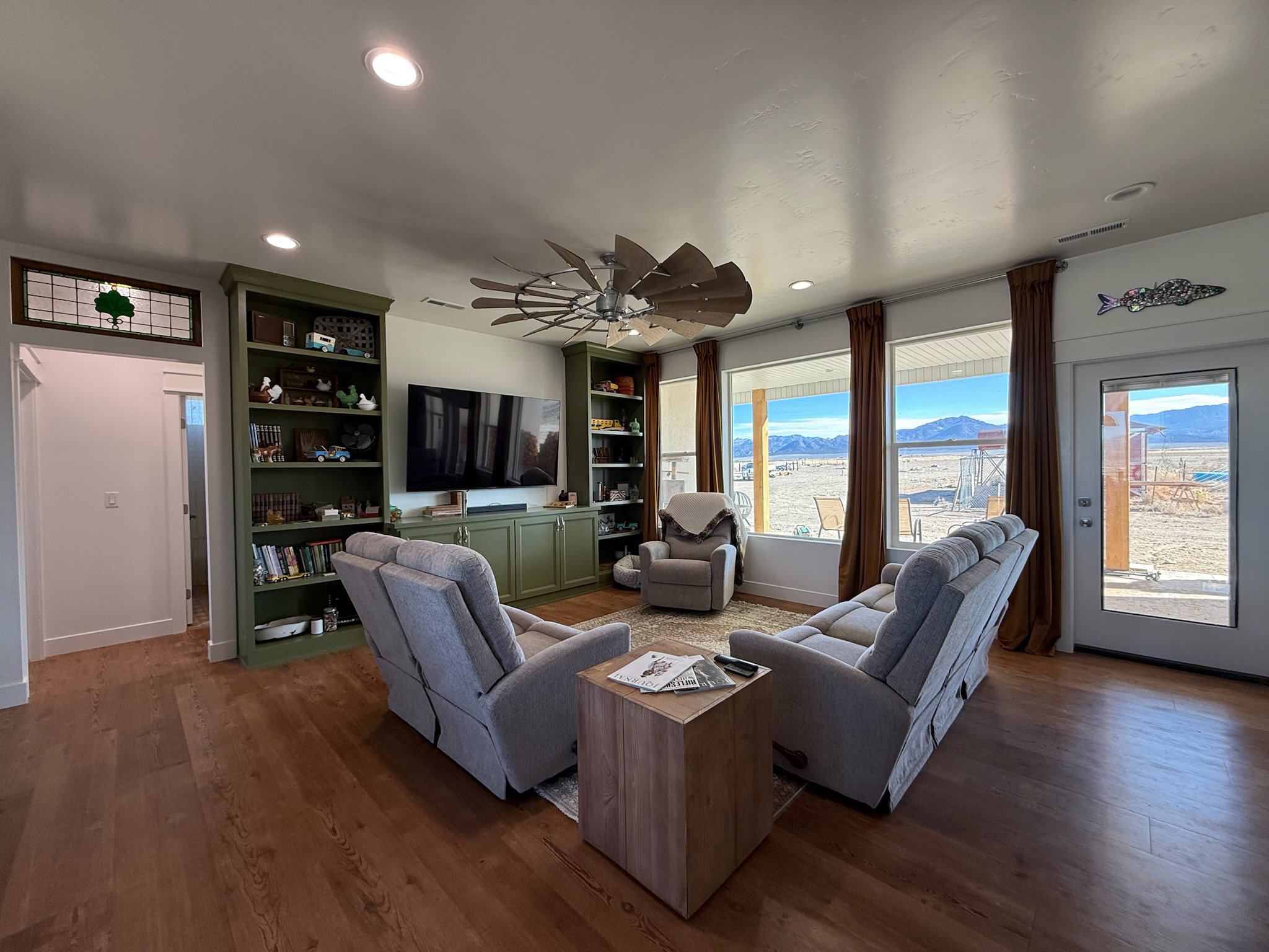 Spacious living area featuring wood-finish flooring, recessed lighting, and a unique ceiling fan