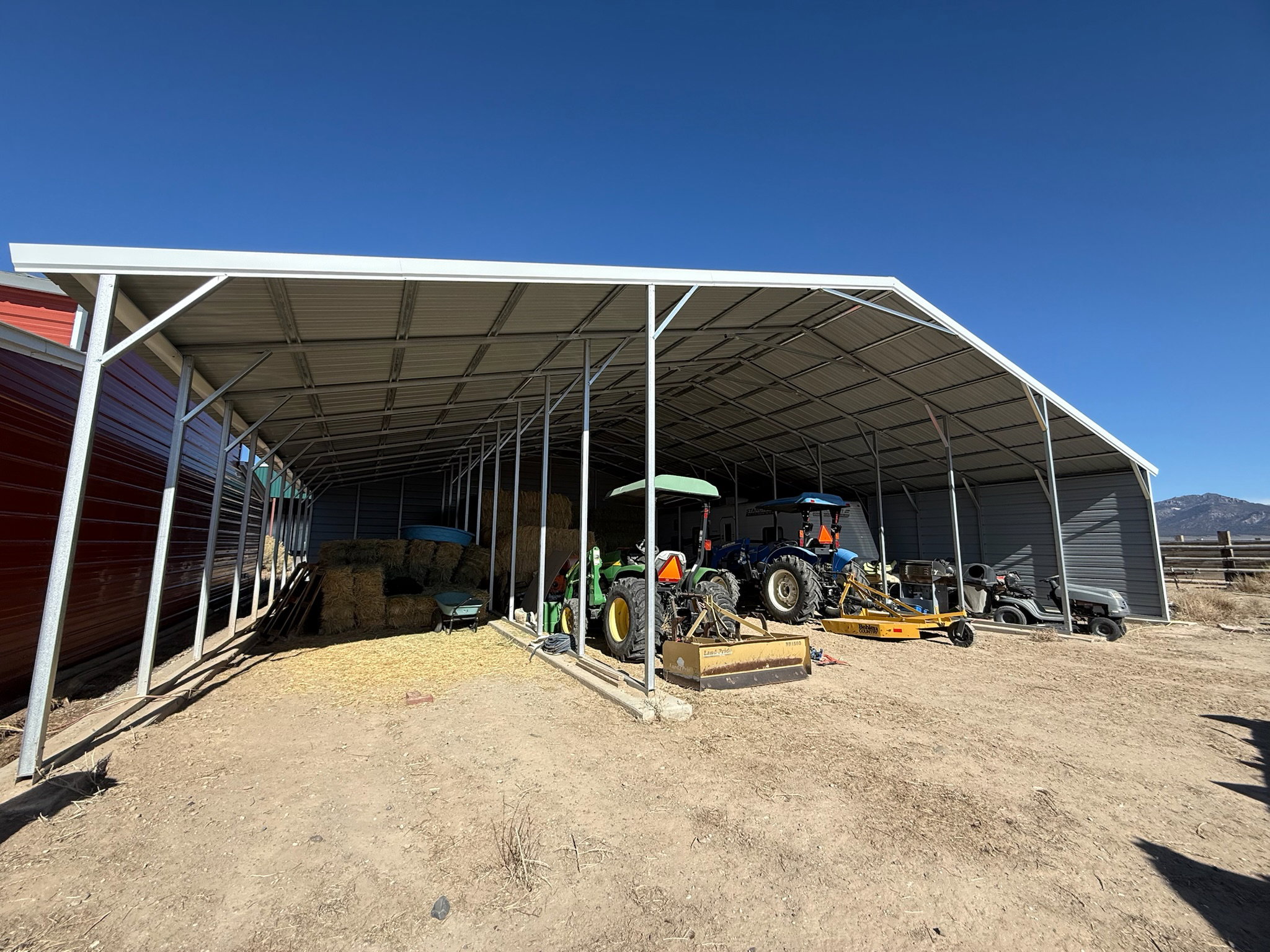 Expansive metal-framed carport featuring a corrugated metal roof and open sides