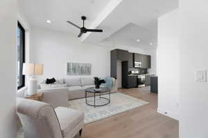 Living room with light wood-type flooring, ceiling fan, and recessed lighting