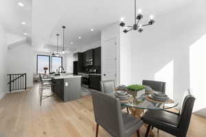 Dining space with light wood finished floors and suspended lighting