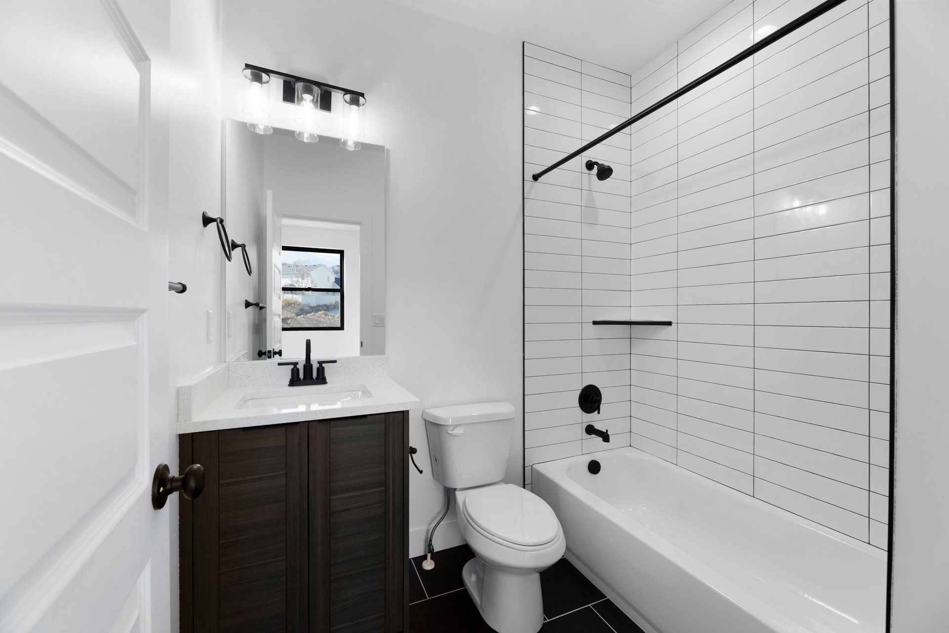 Full bathroom featuring shower / tub combination, vanity, and dark tile patterned flooring