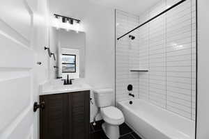Full bathroom featuring shower / tub combination, vanity, and dark tile patterned flooring