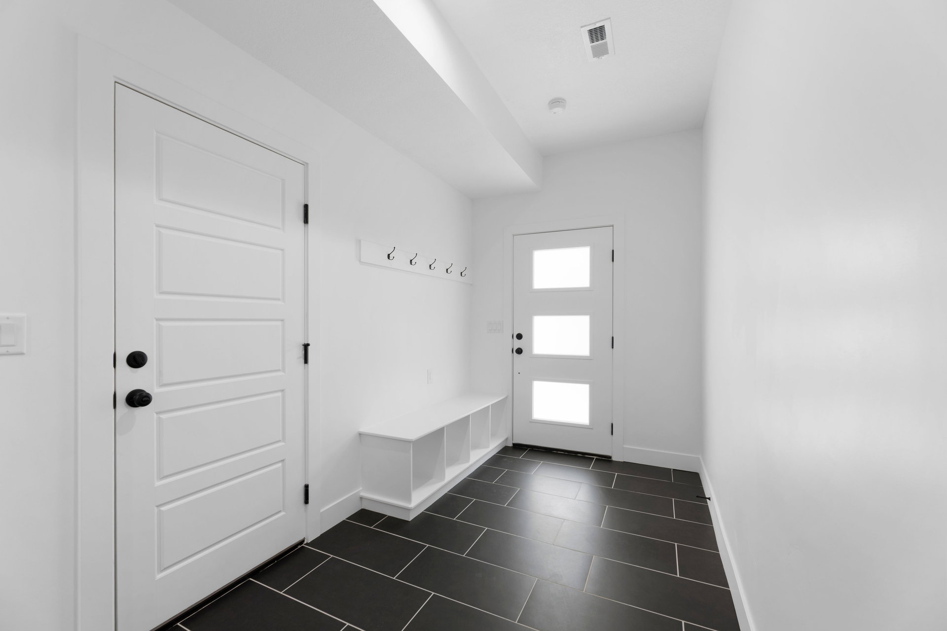 Mudroom with baseboards and dark tile patterned flooring