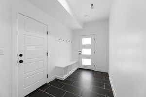 Mudroom with baseboards and dark tile patterned flooring