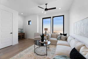 Living room with light wood-type flooring, ceiling fan, and recessed lighting
