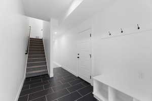 Mudroom with baseboards and dark tile patterned flooring