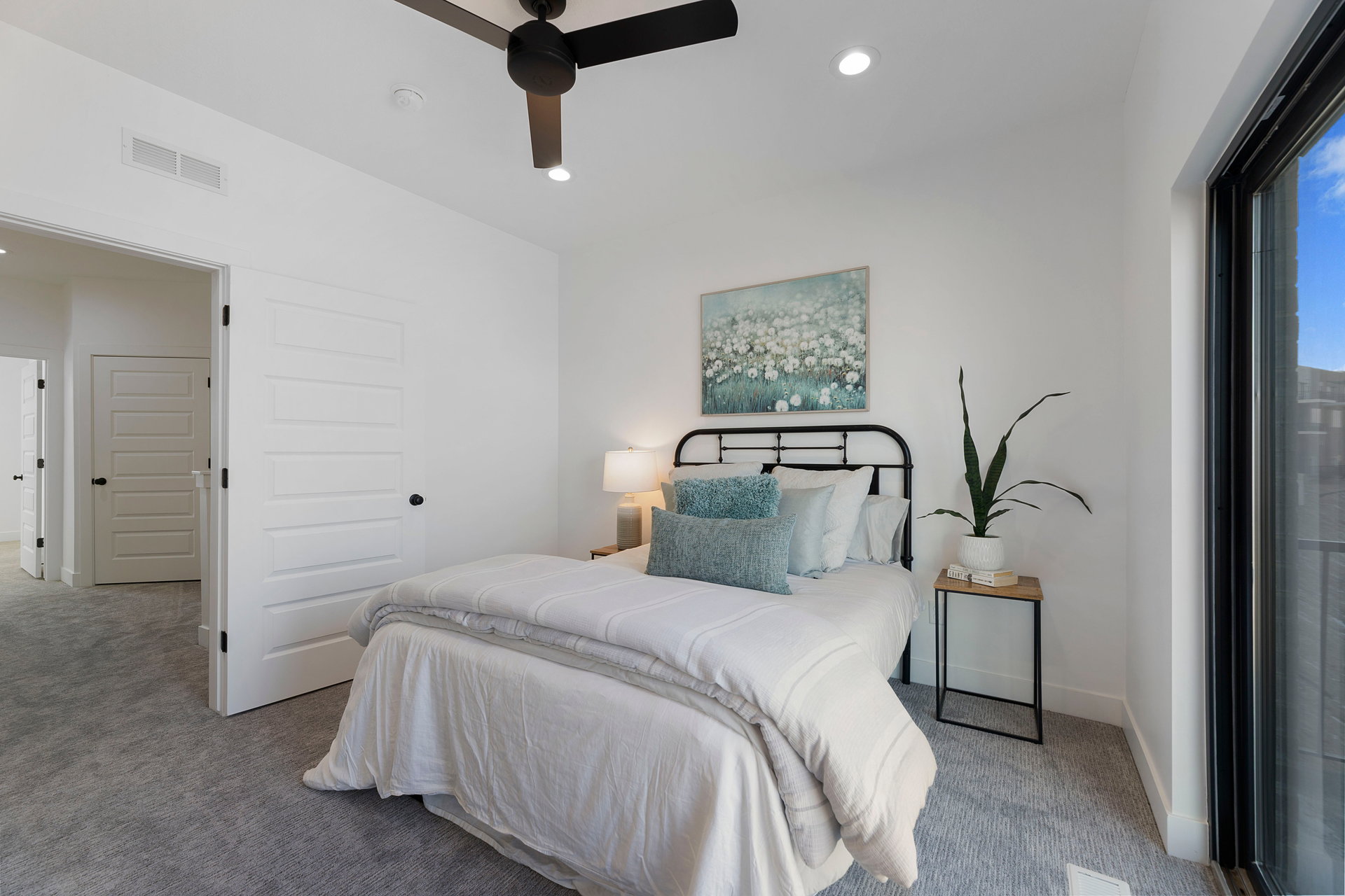 Carpeted bedroom with a ceiling fan and recessed lighting