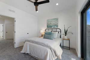 Carpeted bedroom with a ceiling fan and recessed lighting