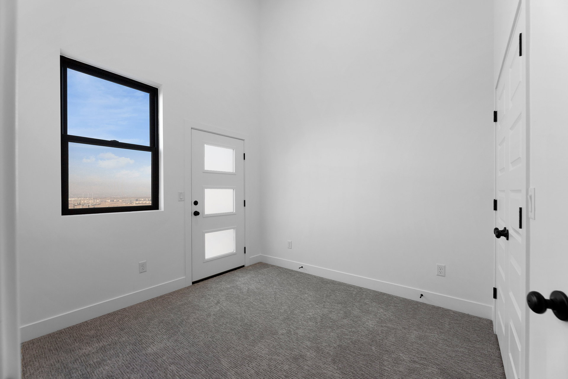Carpeted foyer entrance featuring baseboards and a high ceiling