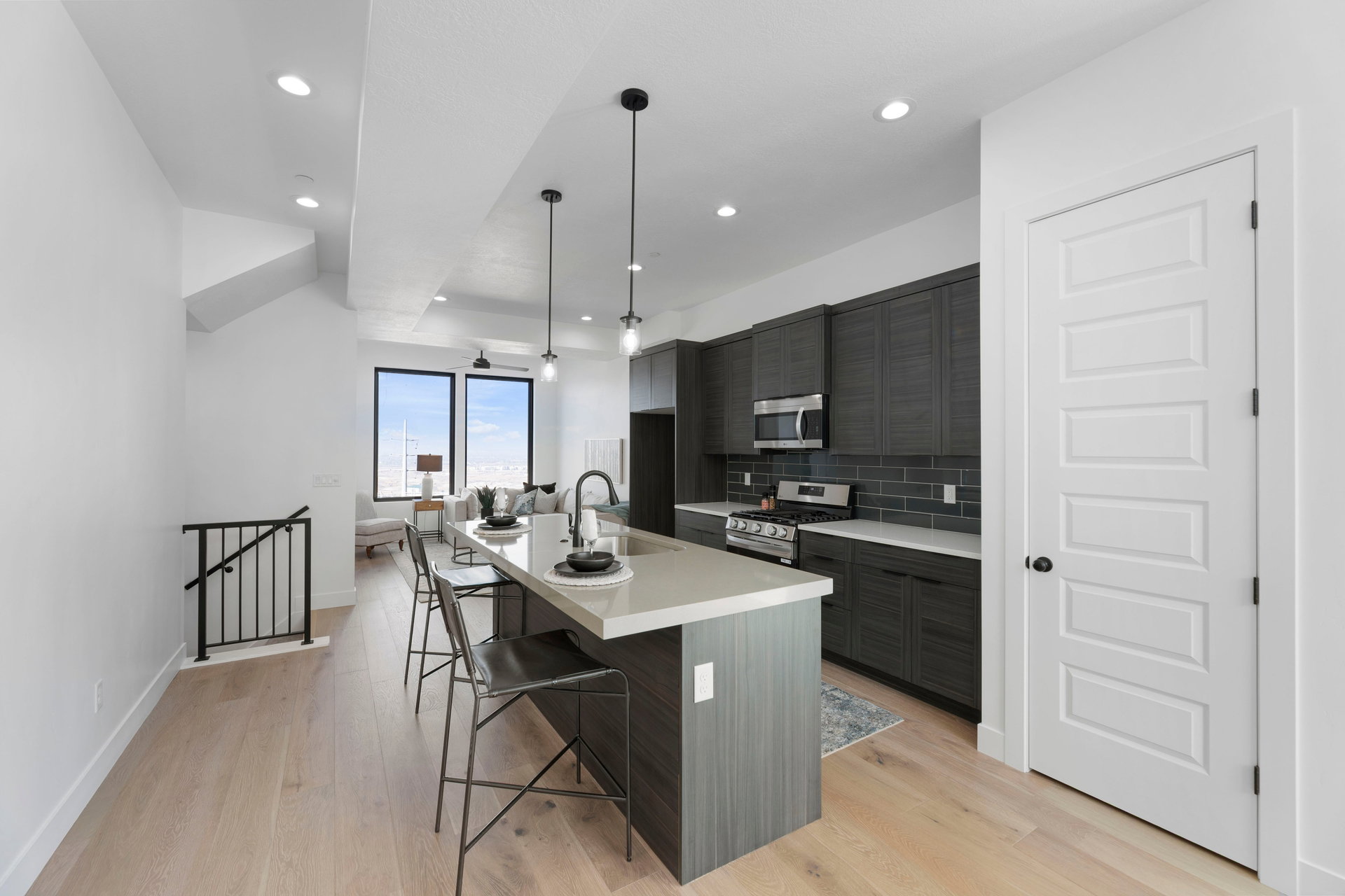 Kitchen with a kitchen bar, a kitchen island with sink, stainless steel appliances, modern cabinets, and light wood finished floors