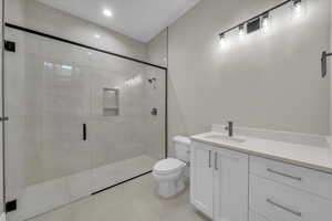 Full bathroom featuring vanity, a shower stall, and recessed lighting
