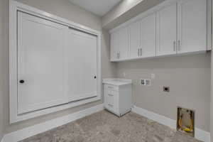 Laundry room with hookup for a washing machine, electric dryer hookup, and cabinet space