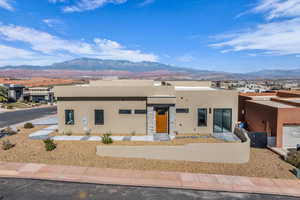 View of front of home featuring stucco siding, a mountain view, and stone siding