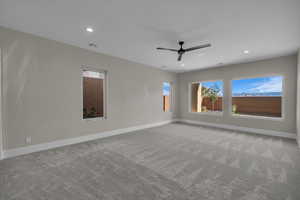 Spare room featuring plenty of natural light, light carpet, recessed lighting, and ceiling fan