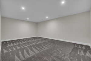 Spare room featuring recessed lighting and dark carpet