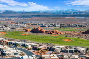 Drone / aerial view of a mountain backdrop and a golf course