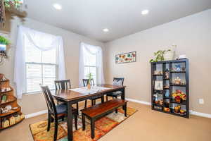 Dining space with light colored carpet and recessed lighting