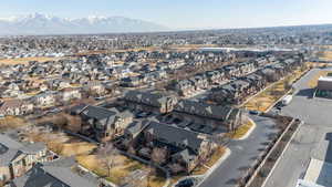 Aerial view of property and surrounding area featuring a mountain backdrop and nearby suburban area