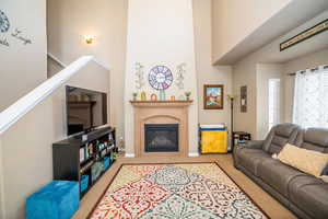 Carpeted living area featuring a high end fireplace and a high ceiling