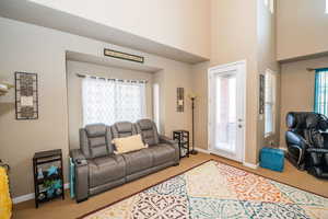 Living room featuring carpet and a high ceiling