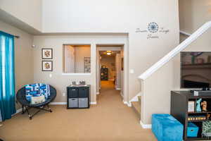 Sitting room featuring carpet flooring and stairway