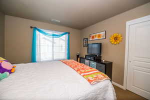 Bedroom with baseboards and dark colored carpet