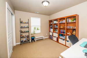Home office with light carpet and baseboards