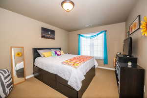 Bedroom with light colored carpet and baseboards