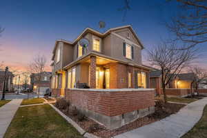 View of front facade featuring brick siding, stucco siding, and a front yard