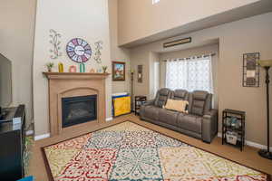 Living room with a high ceiling, a fireplace, healthy amount of natural light, and carpet floors