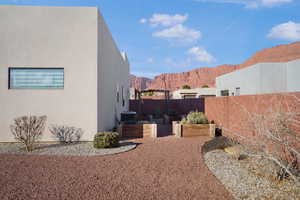 Fenced backyard featuring a vegetable garden, a mountain view, and a patio