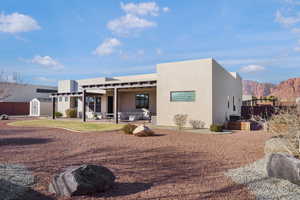 Rear view of property featuring a patio area, stucco siding, a storage shed, a mountain view, and an outdoor hangout area