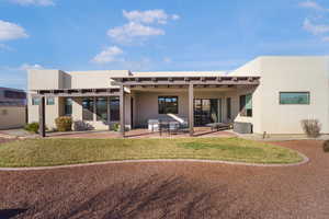 Back of property featuring stucco siding, a patio area, and a yard