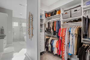Walk in closet featuring light marble finish floors