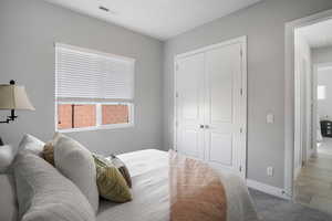 Carpeted bedroom featuring baseboards and a closet