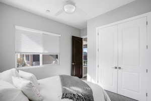 Carpeted bedroom with a closet and ceiling fan