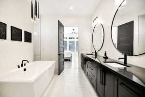 Bathroom with double vanity, a freestanding bath, ensuite bath, recessed lighting, and ceiling fan