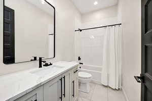 Bathroom with vanity, shower / bathtub combination with curtain, recessed lighting, and light tile patterned floors
