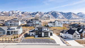 View of front of property featuring concrete driveway, a mountain view, a garage, and a residential view