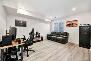 Home office with light wood-style floors and recessed lighting
