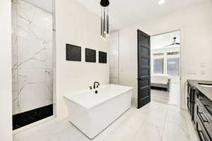 Full bath with ensuite bathroom, vanity, a freestanding tub, a ceiling fan, and recessed lighting