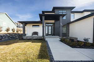 Property entrance with a yard, board and batten siding, and a porch