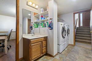 Laundry area with an office area, a textured ceiling, and washing machine and clothes dryer