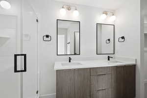 Photo of finished unit - Full bath featuring double vanity and a stall shower