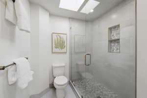 Full bathroom featuring a shower stall, a skylight, and recessed lighting