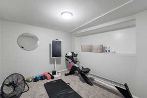 Exercise room with vaulted ceiling and carpet flooring