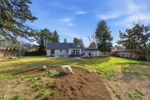 Rear view of property featuring a fenced backyard and a patio