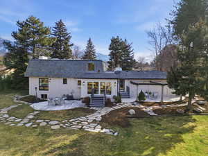 Back of property featuring a patio area, a chimney, and entry steps