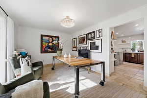 Office area with ornamental molding, a chandelier, and stone tile floors