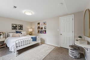 Bedroom with light colored carpet and baseboards